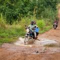 Motorbike driver and health worker delivering vaccines in rural sierra leone