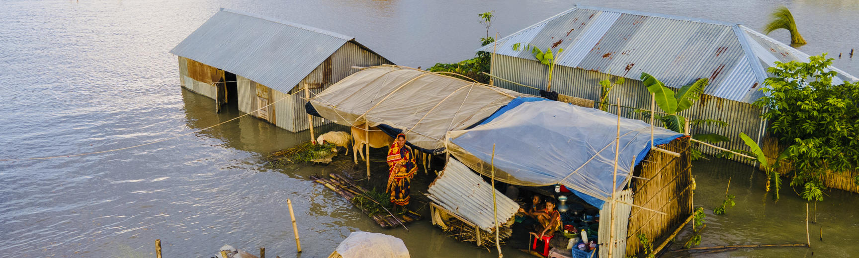 Image of houses stranded in flood water with people inside