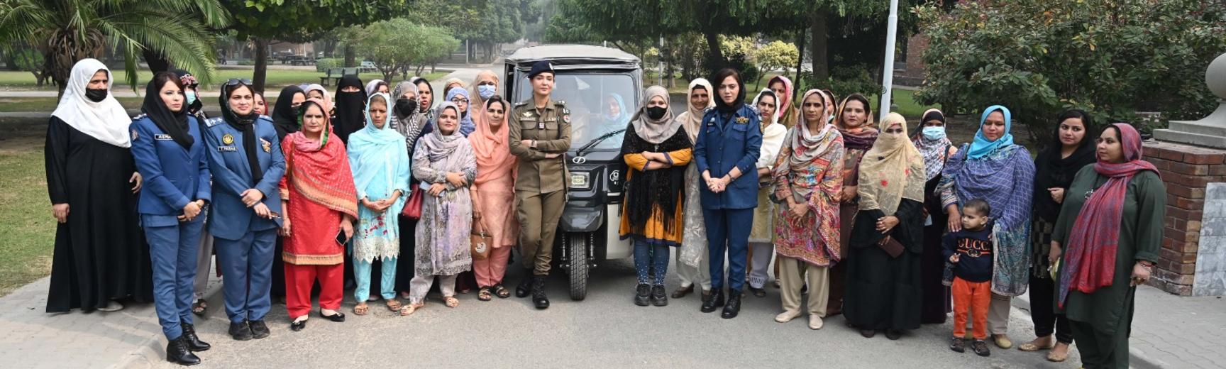 Photograph of group of women gathered by a rickshaw for training in Lahore, Pakistan