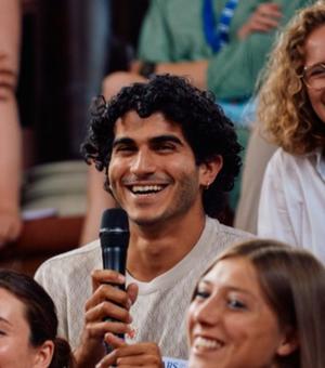 Photo of Justin Hadad holding a microphone in a crowd