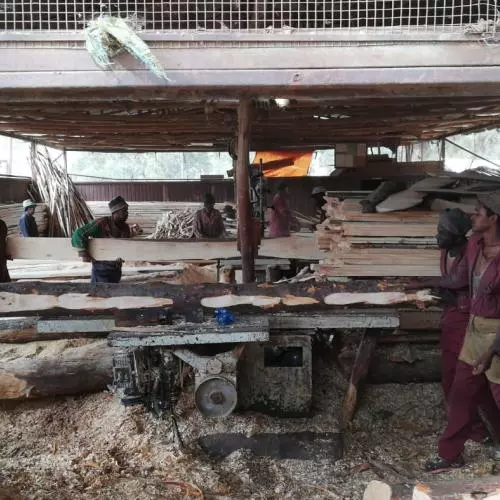 Men carrying planks of wood inside a factory in Addis Ababa