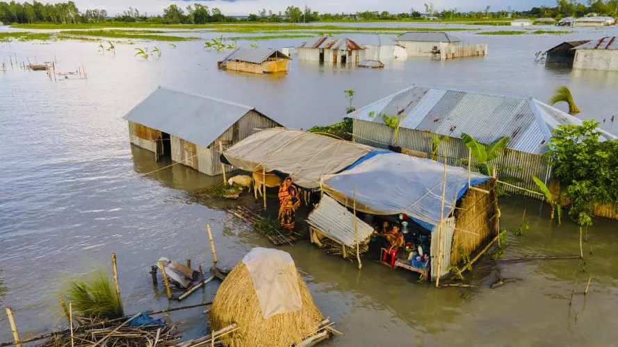 Image of houses stranded in flood water with people inside