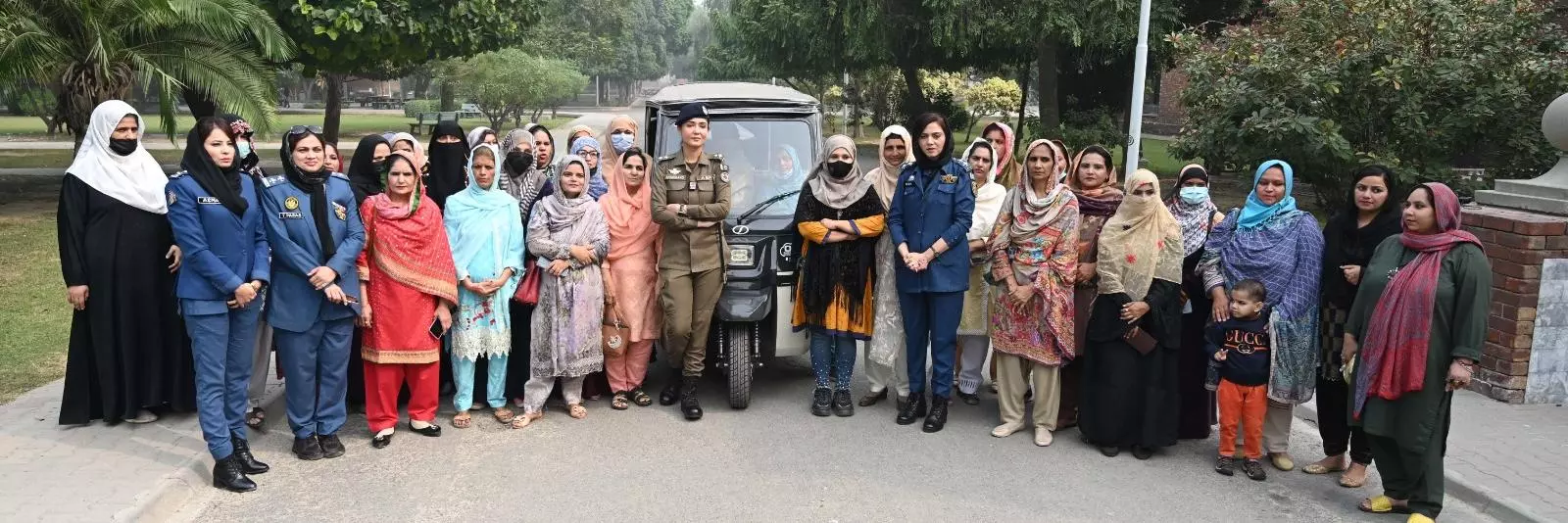 Photograph of group of women gathered by a rickshaw for training in Lahore, Pakistan