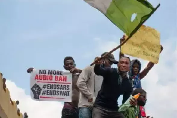men stand on platform waving flags in Nigeria
