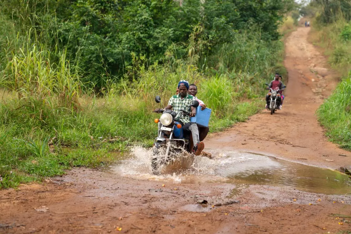 Motorbike driver and health worker delivering vaccines in rural sierra leone
